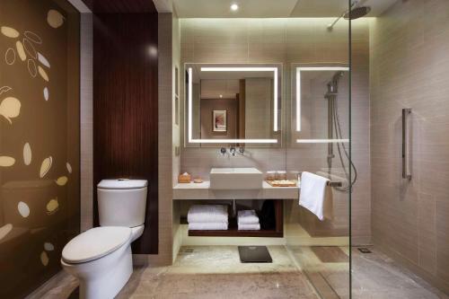 y baño con aseo, lavabo y ducha. en Hilton Garden Inn Shiyan, en Shiyan