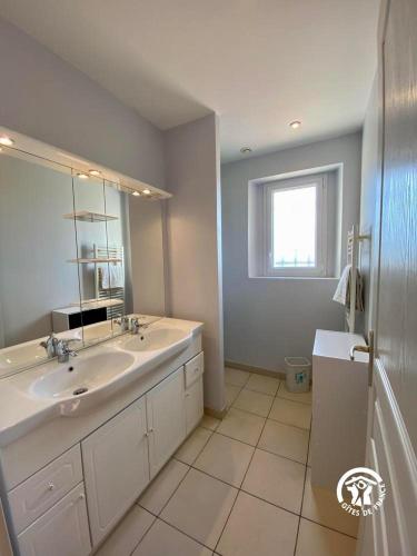 une salle de bain blanche avec un lavabo et un miroir dans l'établissement Le joyaux d'ambre, à La Pomarède