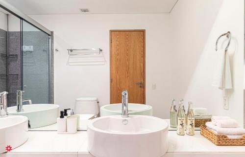 Baño blanco con 2 lavabos y espejo en Casa Reforma by Kukun, en Ciudad de México