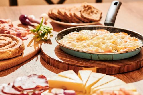 a table with a plate of food with cheese and bread at MoMa Escape in Borje