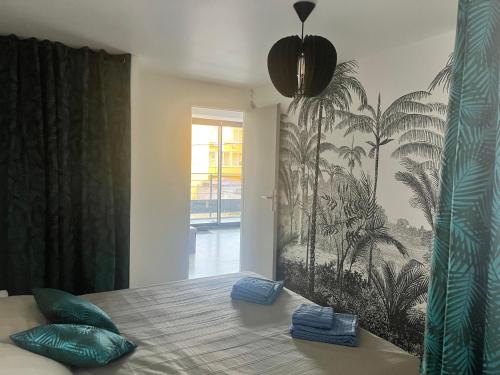 een slaapkamer met een bed met groene kussens en een palmmuurschildering bij OUSTAL CAVAL MARIN A in Valras-Plage