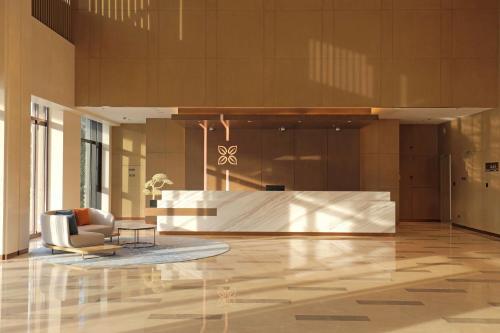 a lobby with a chair and a reception desk at Hilton Garden Inn Changzhou Jintan in Changzhou