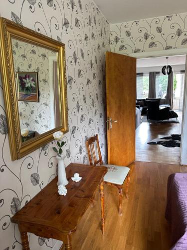 a living room with a wooden table and a mirror at Pråmkanalens Pensionat i Karlstad in Karlstad