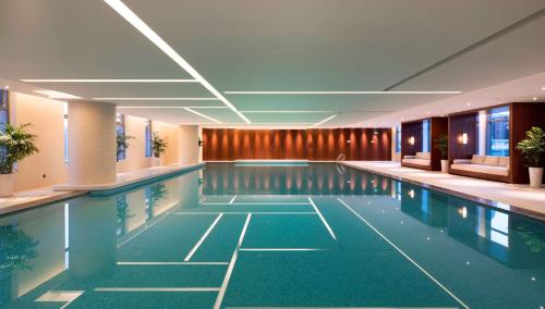 a pool in a building with a swimming pool at DoubleTree By Hilton Ningbo Beilun in Ningbo