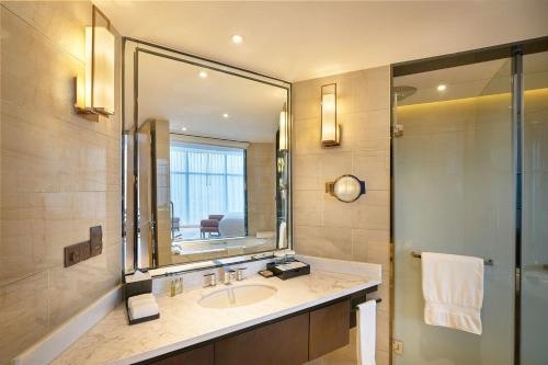 a bathroom with a sink and a mirror at DoubleTree By Hilton Ningbo Beilun in Ningbo