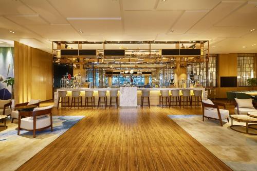 a lobby with a bar with chairs and tables at DoubleTree By Hilton Ningbo Beilun in Ningbo