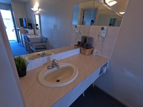 a bathroom with a sink and a mirror at Westview Motel in Vegreville