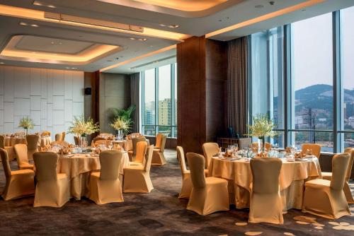 a conference room with tables and chairs and large windows at Hilton Jinan South Hotel & Residences in Jinan