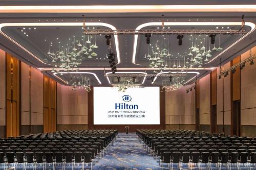 a hall with rows of chairs in front of a screen at Hilton Jinan South Hotel & Residences in Jinan