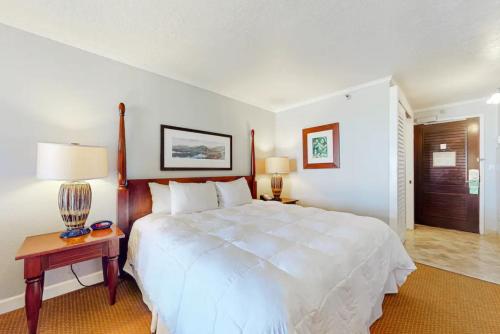 HanamauluにあるCondos in Kauai Beach Resortのベッドルーム(大きな白いベッド1台、ランプ付きテーブル付)