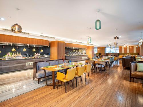 a restaurant with tables and chairs and a bar at Hilton Garden Inn Chengdu Huayang in Chengdu
