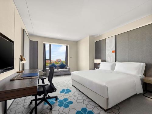 a bedroom with a bed and a desk and a computer at Doubletree By Hilton Baoding in Baoding
