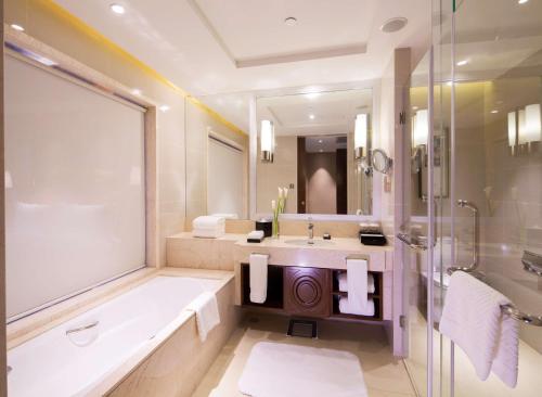 La salle de bains est pourvue d'une baignoire, d'un lavabo et d'une douche. dans l'établissement DoubleTree by Hilton Ningbo - Chunxiao, à Ningbo