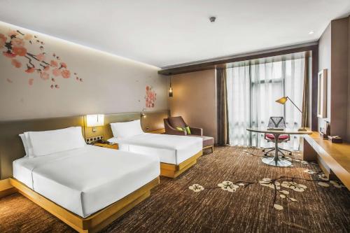 a hotel room with two beds and a desk at Hilton Garden Inn Guiyang Yunyan in Guiyang