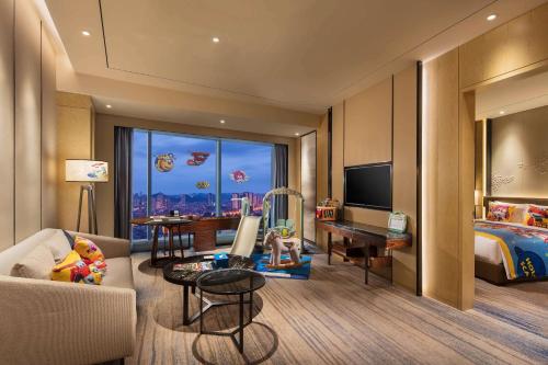 a hotel room with a bedroom with a bed and a desk at DoubleTree by Hilton Hotel Anshun in Anshun