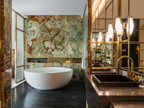 a bathroom with a large tub and a sink at Conrad Shenyang in Shenyang