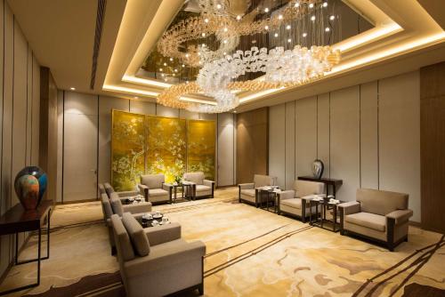 a hotel lobby with chairs and a chandelier at DoubleTree by Hilton Hotel Anshun in Anshun