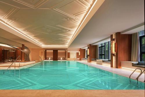 a swimming pool in a hotel with a large blue pool at Conrad Tianjin in Tianjin