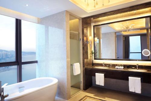 萬州的住宿－重慶萬州富力希爾頓逸林酒店，带浴缸、水槽和镜子的浴室
