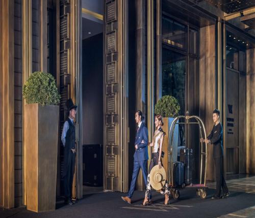 a group of people walking in front of a building at Waldorf Astoria Beijing in Beijing