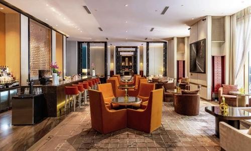 um restaurante com cadeiras e mesas e um bar em Waldorf Astoria Beijing em Pequim