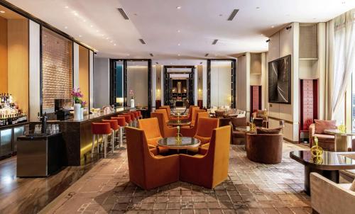 a restaurant with chairs and tables and a bar at Waldorf Astoria Beijing in Beijing