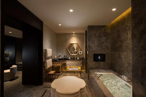 ein Badezimmer mit einer Badewanne und einem Waschbecken in der Unterkunft Waldorf Astoria Beijing in Peking