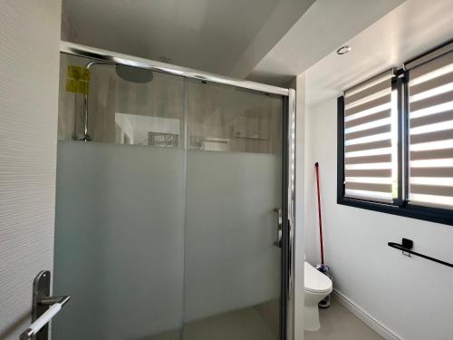 uma cabina de duche em vidro numa casa de banho com WC em OUSTAL CAVAL MARIN A em Valras-Plage