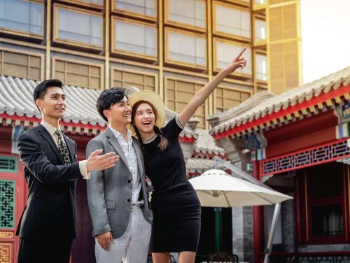 a woman and two men standing in front of a building at Waldorf Astoria Beijing in Beijing