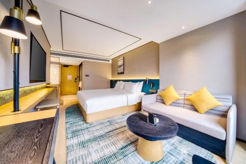 a hotel room with a bed and a couch at Hilton Garden Inn Chengdu Kuanzhai Alley in Chengdu