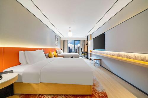a bedroom with a large bed and a tv at Hilton Garden Inn Chengdu Kuanzhai Alley in Chengdu
