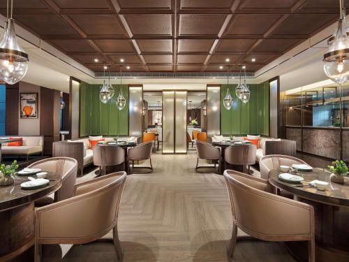 a rendering of a restaurant with tables and chairs at Hilton Taipei Sinban in Taipei