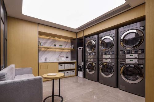 a laundry room with four washing machines and a couch at Hilton Garden Inn Chengdu Kuanzhai Alley in Chengdu