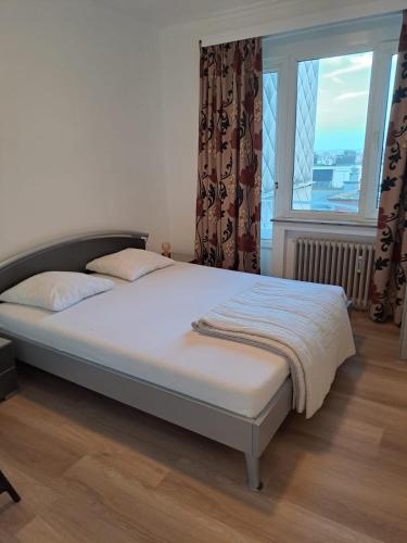 a bed in a bedroom with a large window at Appartement met prachtig zicht op zee in Ostend
