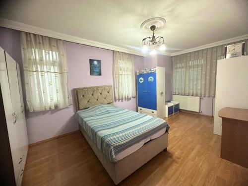 a bedroom with a bed and a blue door at Doğal apart in Trabzon