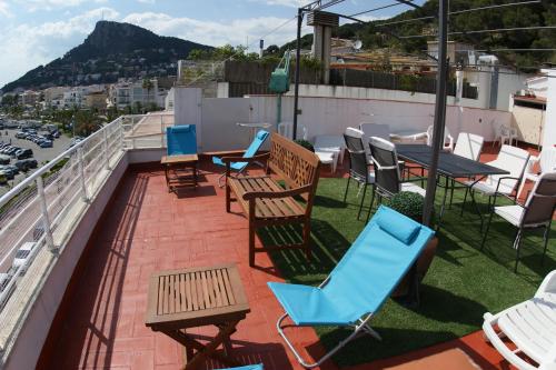 eine Terrasse mit Stühlen und Tischen auf dem Dach in der Unterkunft Hostal Santa Clara in L'Estartit
