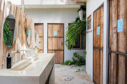 a bathroom with a sink and wooden doors at Hostal Doña Lucha in Tulum