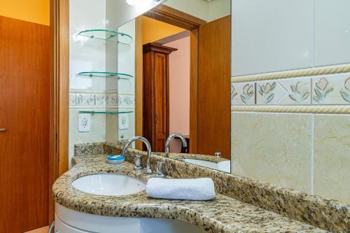 a bathroom with a sink and a mirror at Villagio de Fiore - Stay House Temporada in Gramado