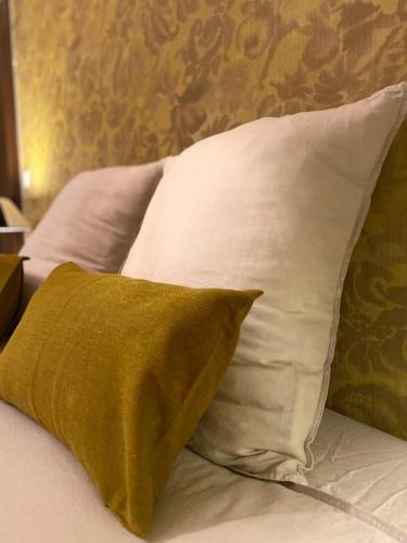 a bed with white pillows and a green pillow at Bastide Aïna SPA et piscine in Grasse