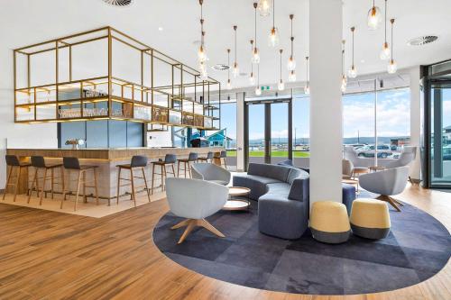 a living room with a bar and a couch and chairs at Hilton Garden Inn Albany, WA in Albany