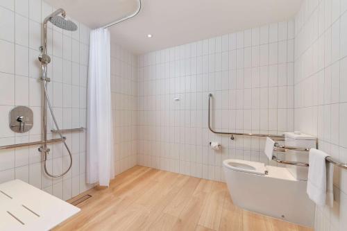 a bathroom with a shower and a toilet and a sink at Hilton Garden Inn Albany, WA in Albany