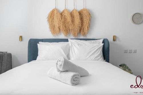 a white bed with towels on top of it at דירה מהממת 50 מטר מהחוף- By Edomlux in Eilat