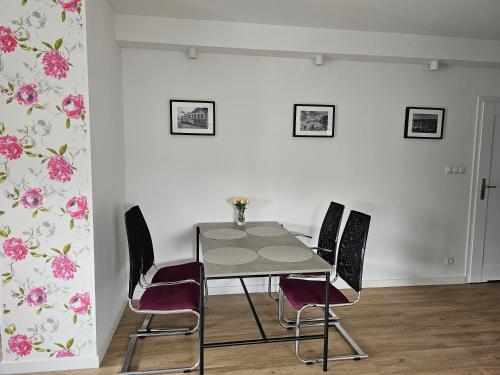 Apartament Flover في يلينيا غورا: طاولة وكراسي في غرفة بها زهور على الحائط