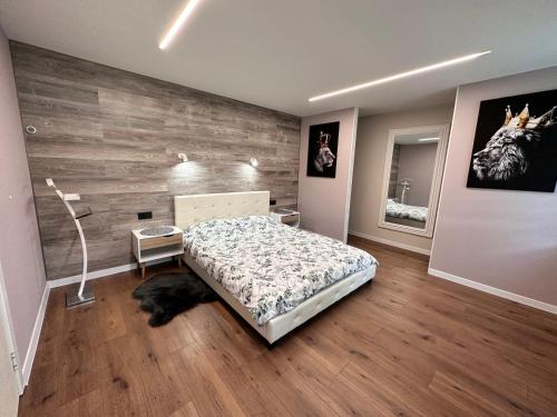 a bedroom with a bed and a wooden wall at Robezu Street House in Liepāja