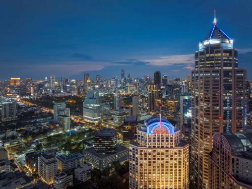 uma vista para o horizonte da cidade à noite em Conrad Bangkok Residences em Bangkok