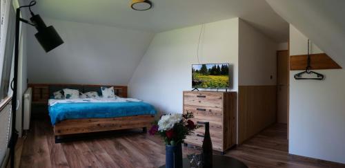 a bedroom with a bed with a blue comforter at Penzion a drevenica pri Hati in Terchová