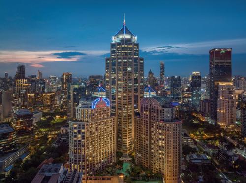 a view of a large city at night at Conrad Bangkok Residences in Bangkok