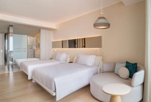 a hotel room with two beds and a couch at Hilton Pattaya in Pattaya Central