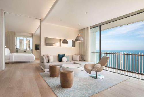 a bedroom with a bed and a living room at Hilton Pattaya in Pattaya Central