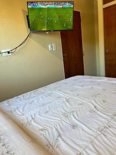 a bedroom with a bed with a television on the wall at Departamento Céntrico bis in Goya